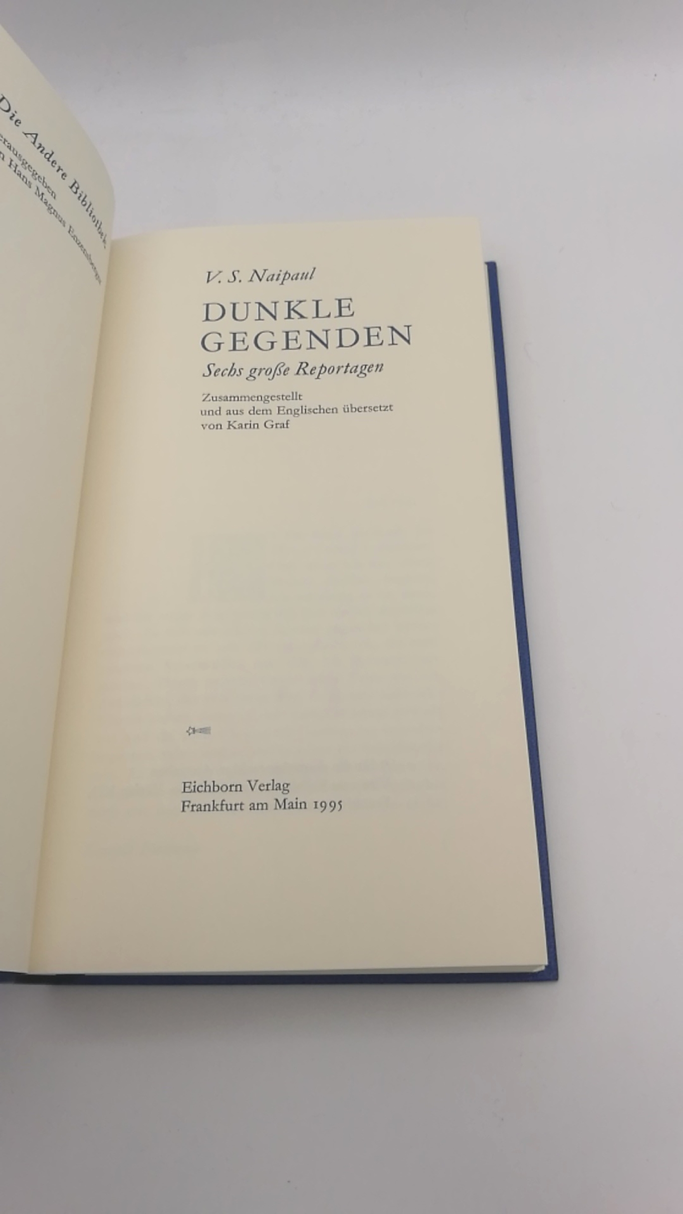 V.S. Naipaul: Dunkle Gegenden. Sechs Reportage. Zusammengestellt und aus dem Englischen übersetzt von Karin Graf. Vorzugsausgabe, gebunden in kobaltblaues Leder. 4. Serie der Anderen Bibliothek "AB 109–144" (hier Band 128). Schwarze, goldgeprägte Rückensc